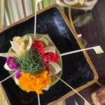 Traditional Balinese Canang Sari offering with flowers and incense